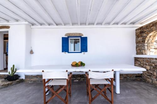 a dining room with a white table and chairs at Blue Serenity Villa in Fanari