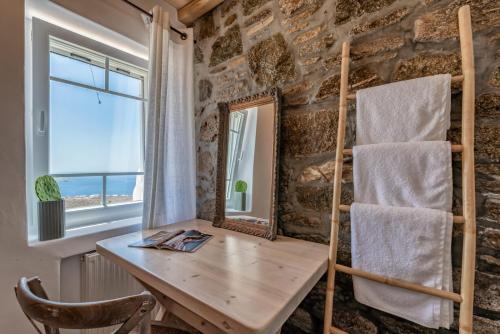 a wooden desk in a room with a window and a chair at Blue Serenity Villa in Fanari