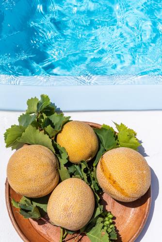 three lemons on a wooden plate next to a swimming pool at Blue Serenity Villa in Fanari