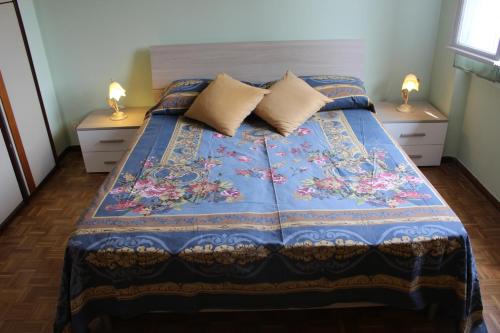een slaapkamer met een blauw bed met twee nachtkastjes bij Brezza di Lago in Salò