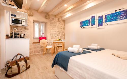 a bedroom with two beds and a small table at Successus Old Town House in Hvar