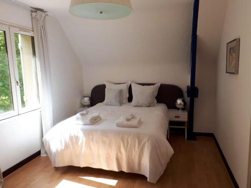 1 dormitorio con 1 cama blanca y 2 toallas en Domaine Providence, en Lassay-sur-Croisne