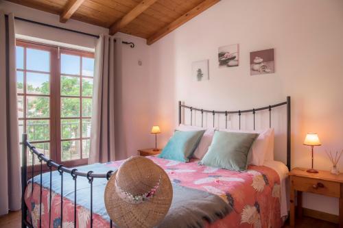 een slaapkamer met een bed met een hoed erop bij Casinha D'Avó Guesthouse in Lagos