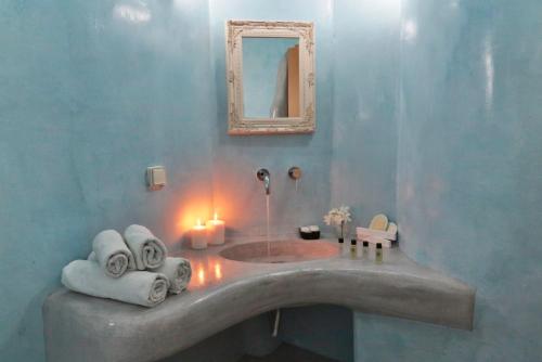 a bathroom with a sink with towels and a mirror at Sakas Residences in Karterados