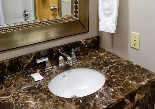 bagno con lavandino e specchio di Westmark Inn Dawson City a Dawson City