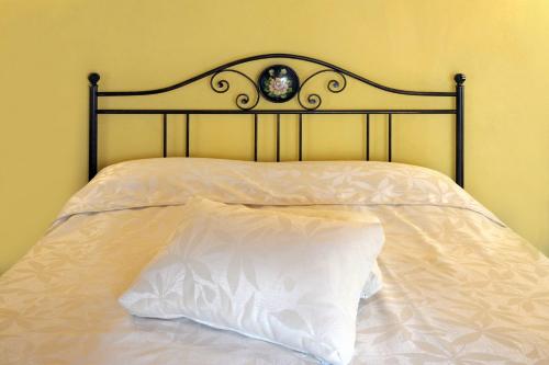 a bed with a black headboard and a white pillow at Palazzo Centro Alloggi Vacanza in Nizza Monferrato
