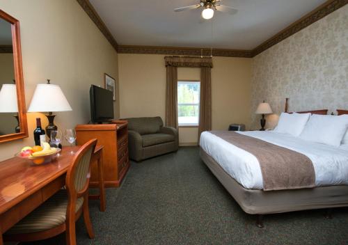 Habitación de hotel con cama y escritorio con ordenador en Westmark Inn Dawson City, en Dawson City