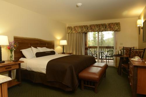 ein Hotelzimmer mit einem Bett und einem Balkon in der Unterkunft Denali Park Village in McKinley Park