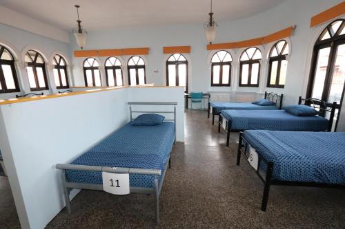 a row of beds in a room with windows at Magnolia Inn in Panama City