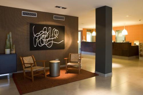 a lobby with two chairs and a painting on the wall at Magnolia Hotel - Adults Only in Salou