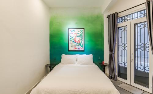 una camera con letto e parete verde di Retro Flat near Nguyen Hue by CIRCADIAN ad Ho Chi Minh
