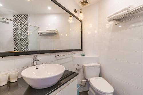 La salle de bains blanche est pourvue d'un lavabo et de toilettes. dans l'établissement Retro Flat near Nguyen Hue by CIRCADIAN, à Hô-Chi-Minh-Ville