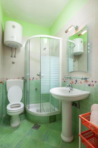a bathroom with a shower and a toilet and a sink at Villa Norah in Podgora