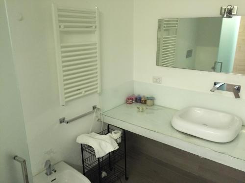 uma casa de banho branca com um lavatório e um espelho em Smile's Home em Catânia