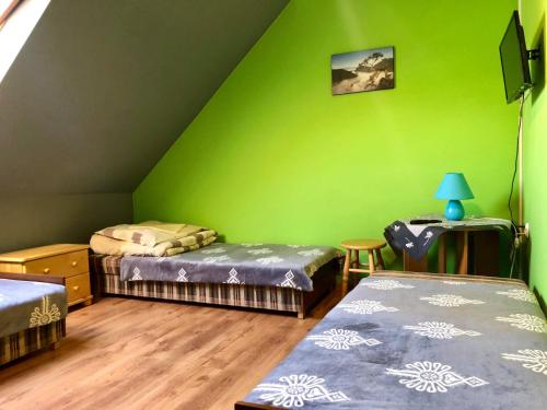 クルシュコフツェにあるApartamenty "U Bańki"の緑の壁の客室で、ベッド2台が備わります。