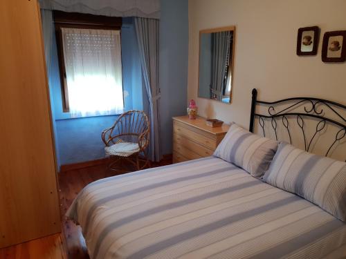 Un dormitorio con una cama y una cómoda y una ventana. en Casa Sara, en Colombres