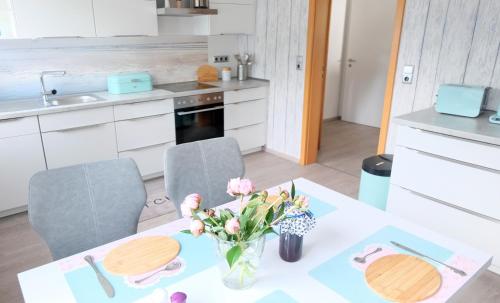 a kitchen with a table with a vase of flowers on it at Heimathafen Weimar in Weimar