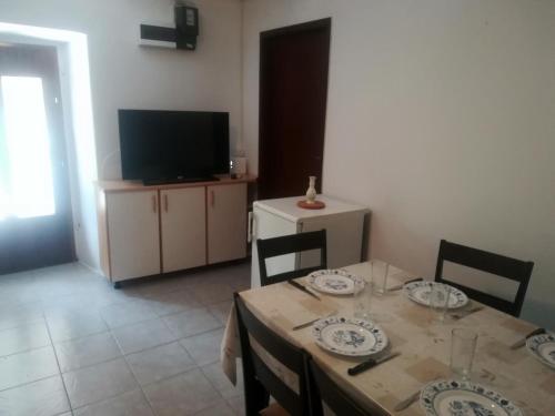 a dining room with a table and a television at Zelena Oaza Mira Bribir in Bribir
