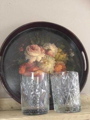 two glasses and a plate with flowers on a table at Bed & Breakfast Yerseke in Yerseke