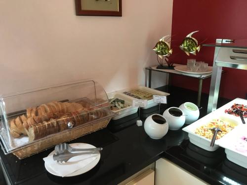 een keuken met een zwart aanrechtblad met brood en gebak bij Apartments Vila 4m in Ražanac