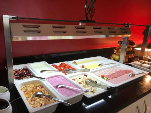 een buffet met veel verschillende soorten eten bij Apartments Vila 4m in Ražanac