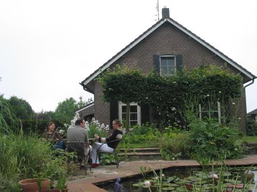 a group of people sitting in front of a house at De Hoge Peel in Heythuysen