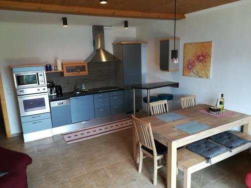 a kitchen with a wooden table and blue cabinets at Ferienwohnung Moralé in Seefeld in Tirol