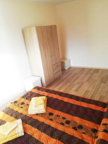 a bedroom with a bed and a wooden floor at Couple getaway to a freshly renovated apartment in Pärnu