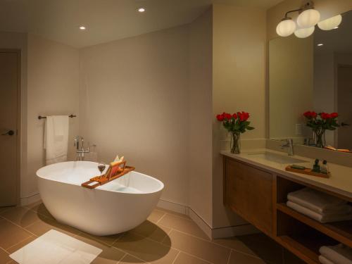 baño con bañera grande y lavamanos en The Ingleside Hotel, en Waukesha