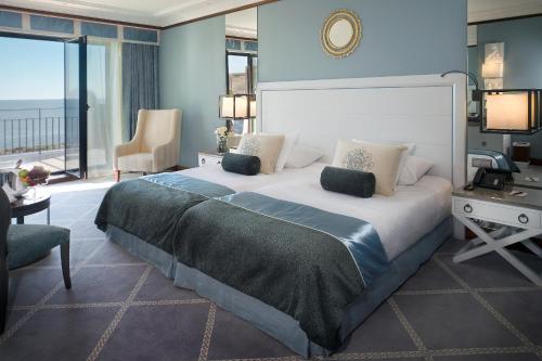 a large bedroom with a large bed and a desk at Grande Real Villa Itália Hotel & Spa in Cascais