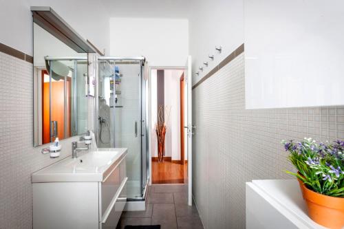 Un baño blanco con lavabo y ducha en Bright House in Milan, en Milán
