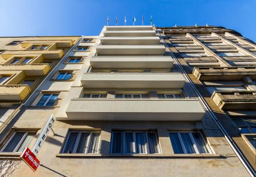 a tall tan building with windows on the side at Vera Cruz Porto Downtown Hotel in Porto