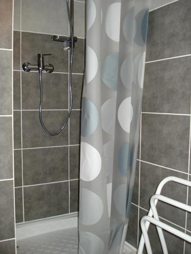 une douche avec un rideau de douche dans une salle de bain dans l'établissement Jolis Studios vue sur mer Port, Etangs et Canaux Résidence RIVERCITY, à Carnon-Plage