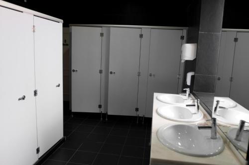 bagno con 3 lavandini e armadi bianchi di Lisb'on Hostel a Lisbona
