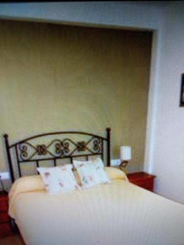 a bed with white sheets and pillows in a bedroom at VIVIENDA TURISTICA MARANt 2 in El Puerto de Santa María