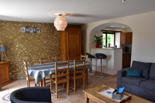 ein Wohnzimmer mit einem Tisch und einem Sofa in der Unterkunft Gîte La Lichère - La Chanterelle in Saint-Montan