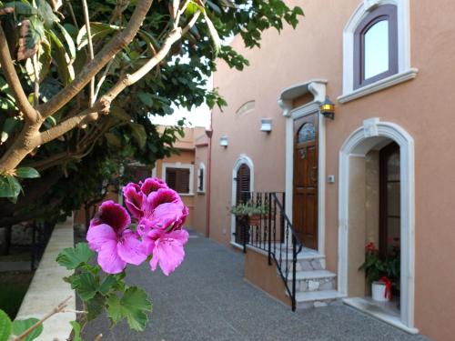 a pink flower in front of a building at Villa Musica in Sannicola