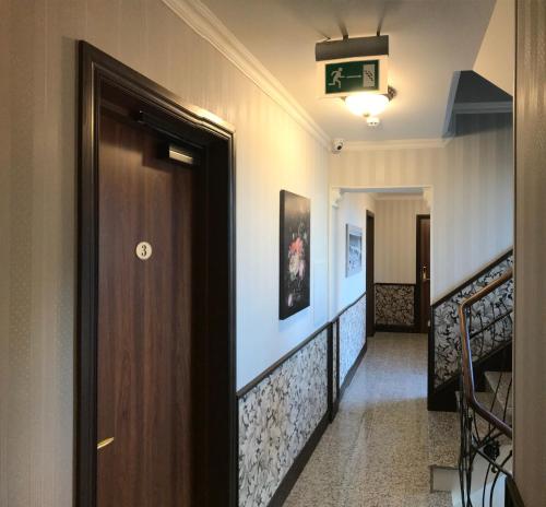 a hallway with a wooden door and stairs at KEY for REST in Palanga