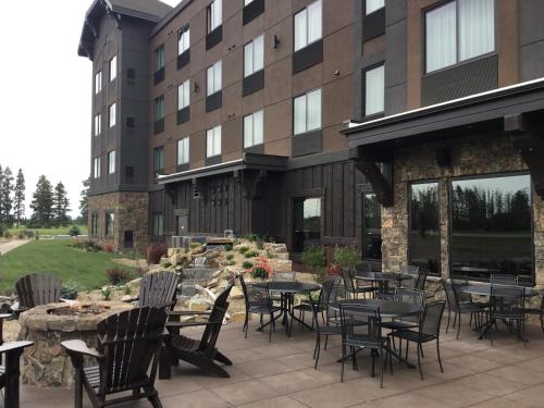 a patio with tables and chairs in front of a building at Glacier International Lodge in Kalispell