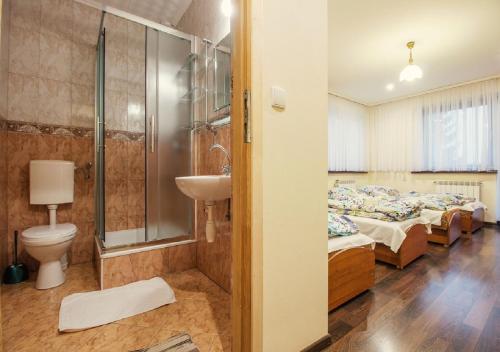 ザコパネにあるWilla Kamilaのベッド4台、シャワー、シンクが備わる客室です。