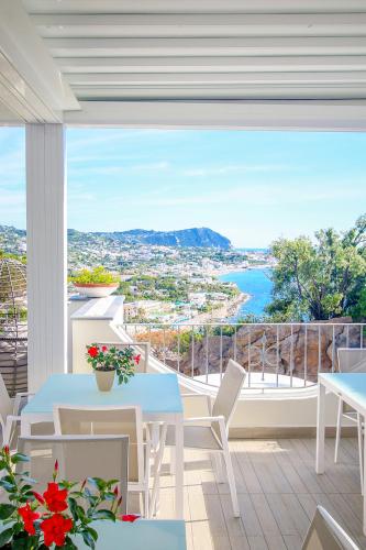 a balcony with tables and chairs and a view of the ocean at Villa Caruso in Ischia