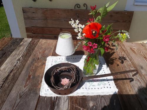 a table with a vase of flowers and a candle at Ferienhaus Niedernsill in Niedernsill