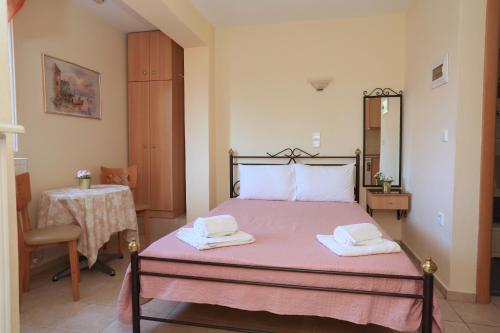 a bedroom with a bed with two towels on it at Katerina Apartments in Pefkochori
