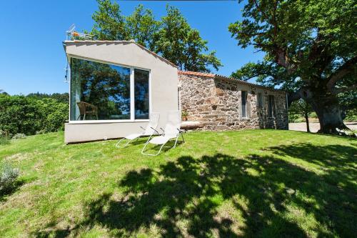 a house on a hill with two chairs on the grass at Casa das Landras in Chantada