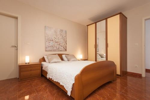 a bedroom with a bed and a painting on the wall at Apartments Alice in Rovinj