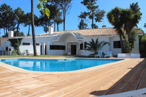 a villa with a swimming pool in front of a house at Villa near Beach & Lisbon in Corroios