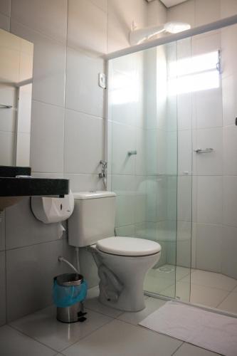 a bathroom with a toilet and a glass shower at Ello Hotel in Iguatu
