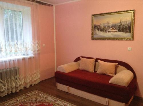 a living room with a couch in front of a window at Вікторія in Tatariv