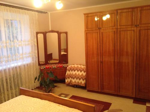 a bedroom with a dresser and a large mirror at Вікторія in Tatariv
