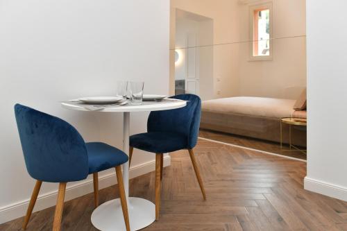a table with two blue chairs in a room at Luxury Studio next to Monte Carlo in Beausoleil